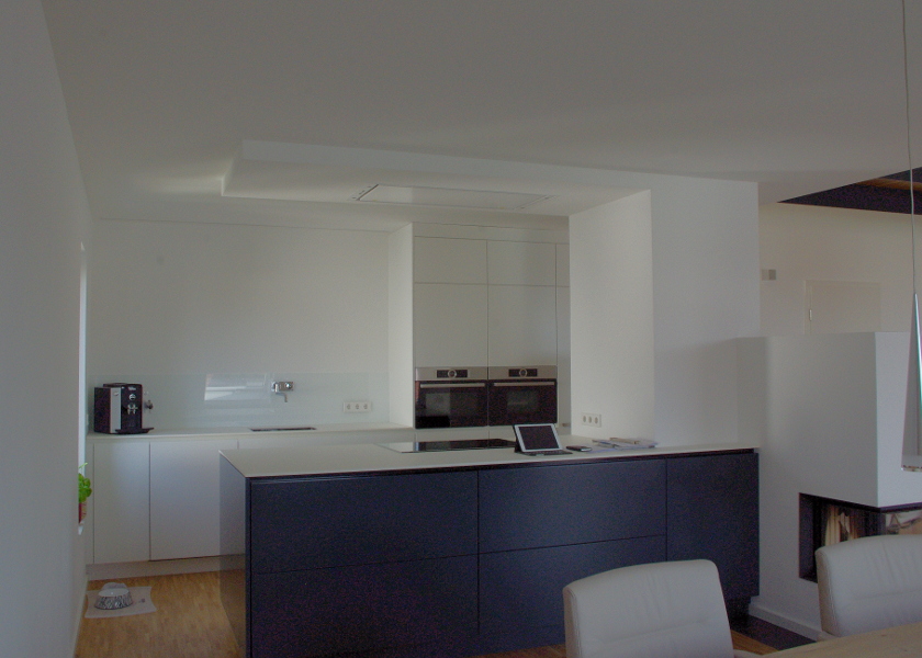 Eine moderne weiße Küche in einem Neubauhaus.