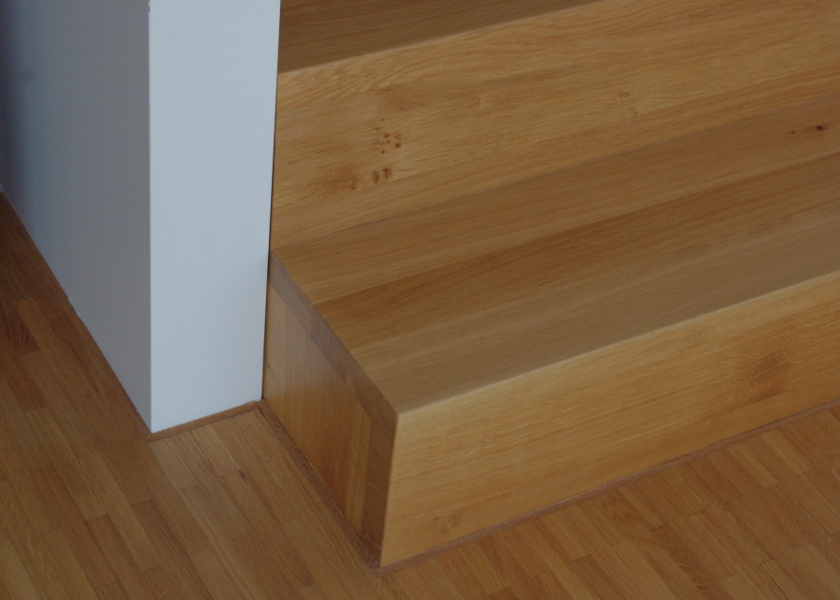 Nahaufnahme einer Holztreppe in einem Neubauhaus.