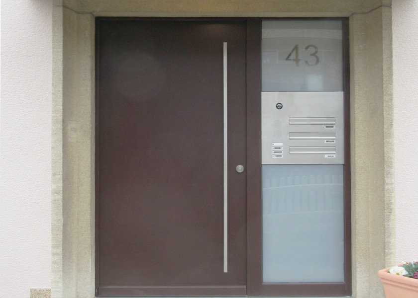 Dunkle Haustüre eines Mehrfamilienhauses.
