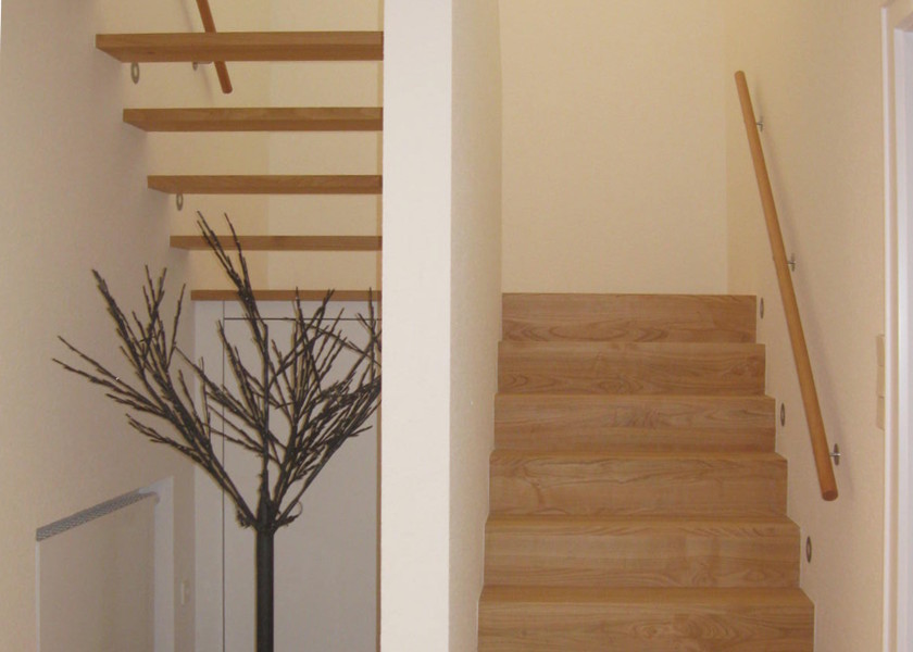 Holztreppe innerhalb eines Mehrfamilienhauses.
