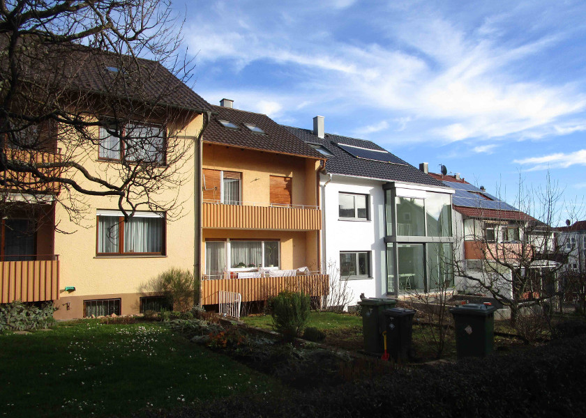 Hinteransicht eines Reihenendhaus mit Wintergartenverglasung.