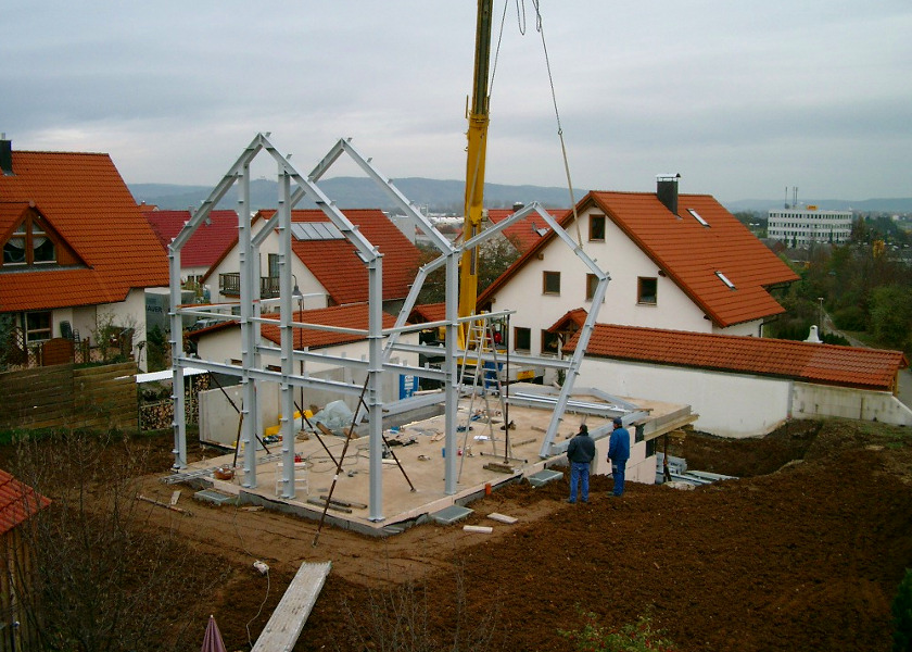 Handwerker am Aufstellen des Stahlskeletts für ein Haus.