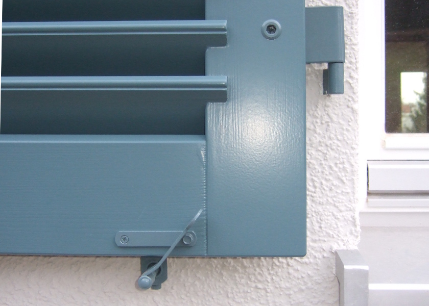 Holzfensterladen in grau blau lackiert.