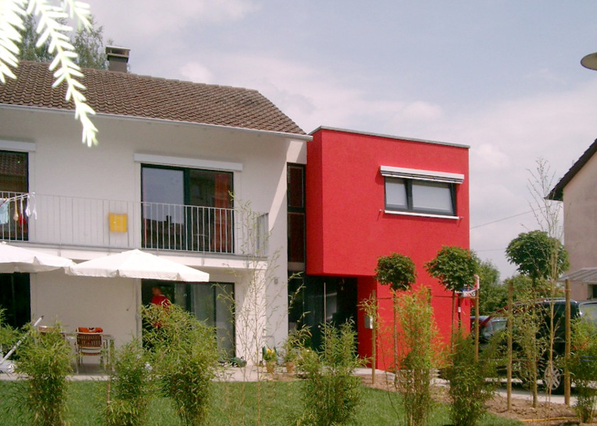 Roter Anbau an einem Familienhaus.
