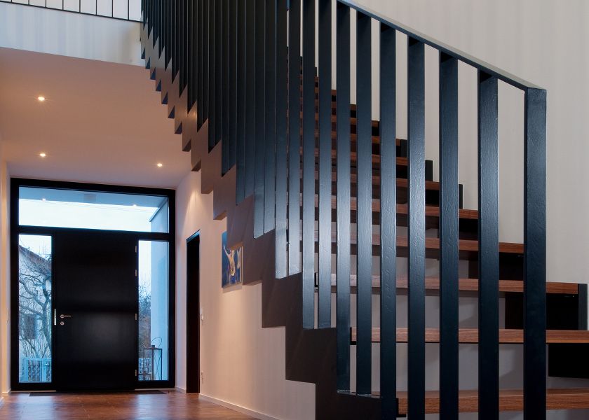 Flachstahlgeländer einer Holztreppe.